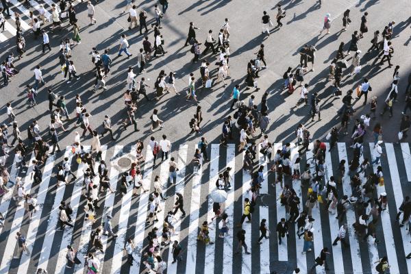 Photo of a large group of people crossing a road 