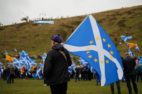 Man holds Scotland flag with EU stars on it